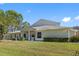 Spacious single-Gathering home with well-manicured lawn, mature trees, and a light-colored facade on a bright day at 3203 Audubon Ct, Tarpon Springs, FL 34688