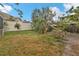 Backyard with a fallen palm tree and patchy grass at 512 Acacia Ln, Nokomis, FL 34275