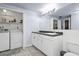 Bathroom includes white cabinets, toilet and laundry area at 512 Acacia Ln, Nokomis, FL 34275