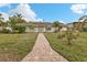 Brick ranch home with a landscaped lawn and brick walkway at 512 Acacia Ln, Nokomis, FL 34275