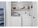 Laundry room with washer, dryer, and extra storage shelves at 512 Acacia Ln, Nokomis, FL 34275