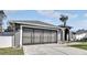 Gray house with a three-car garage and nicely landscaped yard at 5156 Mentmore Ave, Spring Hill, FL 34606