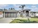 Gray house with a three-car garage and landscaped lawn at 5156 Mentmore Ave, Spring Hill, FL 34606