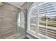 Shower with wood-look tile and an arched window with shutters at 5156 Mentmore Ave, Spring Hill, FL 34606