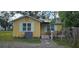 Cute yellow cottage with solar panels, small deck, and fenced yard at 6404 Pershing Ne St, St Petersburg, FL 33702