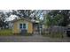 Cute yellow cottage with solar panels, small deck, and fenced yard at 6404 Pershing Ne St, St Petersburg, FL 33702