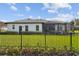 House back view, fenced backyard, screened patio, and lush green lawn at 9202 Everwood Ct, Tampa, FL 33647