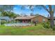 A fenced backyard with a pool, surrounded by green grass and lush landscaping at 1307 Windjammer Pl, Valrico, FL 33594