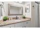 Bathroom with granite countertops, decorative mirror, and white cabinets at 1307 Windjammer Pl, Valrico, FL 33594