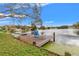Scenic lake view featuring a private wooden dock, chair, and lush greenery at 1307 Windjammer Pl, Valrico, FL 33594
