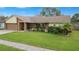 Charming single-story home with well-manicured lawn, mature trees, and attached garage at 1307 Windjammer Pl, Valrico, FL 33594
