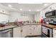 Charming kitchen featuring white cabinets, stainless steel appliances, and a breakfast bar at 1307 Windjammer Pl, Valrico, FL 33594