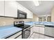 View of kitchen with stainless steel appliances and light blue countertops at 14625 Par Club Cir, Tampa, FL 33618