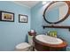 Small bathroom with pedestal sink, toilet, and decorative mirror at 17960 Gulf Blvd # 115, Redington Shores, FL 33708
