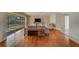 Living area with hardwood floors, a large window overlooking the backyard, and comfortable seating at 1803 Southwood Ln, Clearwater, FL 33764
