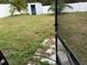 Backyard view from screened enclosure, showing grassy area and shed at 18229 Port Side St, Tampa, FL 33647