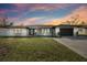 Stunning mid-century modern home with a white exterior, black accents, and a landscaped lawn at 26728 Hickory Loop, Lutz, FL 33559