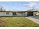 Stunning curb appeal featuring a renovated single-story home with modern facade and landscaped lawn at 26728 Hickory Loop, Lutz, FL 33559