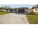 Modern home exterior with a black garage door and a spacious driveway at 26728 Hickory Loop, Lutz, FL 33559