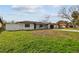 Newly constructed home with a modern exterior, showcasing a black garage door and green lawn at 26728 Hickory Loop, Lutz, FL 33559