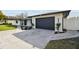 Modern home with a black garage door and landscaping at 26728 Hickory Loop, Lutz, FL 33559