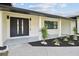 Modern house exterior featuring a black roof and front door, landscaping, and a paved driveway at 26728 Hickory Loop, Lutz, FL 33559