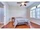 Cozy bedroom with hardwood floors, shuttered window, and ceiling fan at 3406 Ranchdale Dr, Plant City, FL 33566