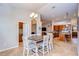An open-concept dining area showcases a chandelier and connects to a kitchen with wood cabinetry and tile flooring at 3406 Ranchdale Dr, Plant City, FL 33566