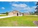Charming home with a manicured lawn, three-car garage, and lovely architectural details on a sunny day at 3406 Ranchdale Dr, Plant City, FL 33566