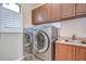 Laundry room with modern washer and dryer, countertop, and cabinets at 3406 Ranchdale Dr, Plant City, FL 33566