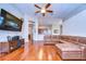 Spacious living room with hardwood flooring, an entertainment center, and leather furniture at 3406 Ranchdale Dr, Plant City, FL 33566