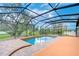 Enclosed pool area with screened enclosure, brick patio, and tranquil views at 3406 Ranchdale Dr, Plant City, FL 33566