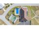 Aerial view of a community pool, shuffleboard court, and clubhouse with ample parking at 35934 Verano Ln, Zephyrhills, FL 33541