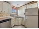 Compact kitchen with white cabinets, stainless steel appliances, and tile flooring at 35934 Verano Ln, Zephyrhills, FL 33541