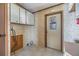 Practical laundry area with tile flooring, storage cabinets, and access to the outdoors at 35934 Verano Ln, Zephyrhills, FL 33541