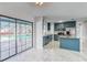 Modern kitchen with teal cabinets, granite counters, and a view of the pool at 404 13Th Sw St, Ruskin, FL 33570