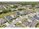 An aerial view of a neighborhood with well-maintained homes, lush lawns, and community lakes and green space at 4735 Rolling Green Dr, Wesley Chapel, FL 33543