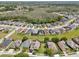 Expansive aerial view of a residential neighborhood featuring lush landscaping and a tranquil lake at 4735 Rolling Green Dr, Wesley Chapel, FL 33543