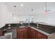 Dark countertop bar area complete with cabinets, mini-sink, wine rack and unique pendant lighting at 4735 Rolling Green Dr, Wesley Chapel, FL 33543