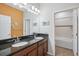 Well lit bathroom featuring double vanity with dark granite countertop and a shower-tub combo at 4735 Rolling Green Dr, Wesley Chapel, FL 33543