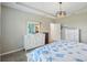 Comfortable bedroom featuring a tray ceiling, dresser, and a charming seashell themed quilt at 4735 Rolling Green Dr, Wesley Chapel, FL 33543
