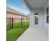 View of the concrete covered patio with access door and grass area, perfect for entertaining at 4735 Rolling Green Dr, Wesley Chapel, FL 33543
