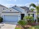 Charming single-Gathering home featuring a two-car garage, well-manicured lawn, and lush landscaping at 4735 Rolling Green Dr, Wesley Chapel, FL 33543
