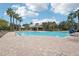 Community pool featuring sparkling water, palm trees, shaded seating and a bath house for relaxing and refreshing at 4735 Rolling Green Dr, Wesley Chapel, FL 33543