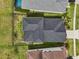 Aerial view of a dark gray architectural shingle roof surrounded by green grass and residential houses at 4735 Rolling Green Dr, Wesley Chapel, FL 33543