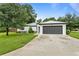 Newly constructed home with a modern exterior, dark gray garage door, and nicely landscaped lawn at 5001 22Nd N St, St Petersburg, FL 33714