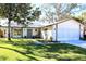One-story house with attached garage, and landscaped lawn at 8040 Pasadena Dr, Port Richey, FL 34668