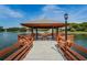 Community gazebo with lake view, picnic tables, and wooden walkway at 8040 Pasadena Dr, Port Richey, FL 34668