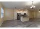 Open kitchen with granite countertops, stainless steel appliances, and gray vinyl flooring at 9042 Moonlit Meadows Loop, Riverview, FL 33578