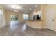 Open concept living and kitchen area with gray vinyl flooring and patio access at 9042 Moonlit Meadows Loop, Riverview, FL 33578